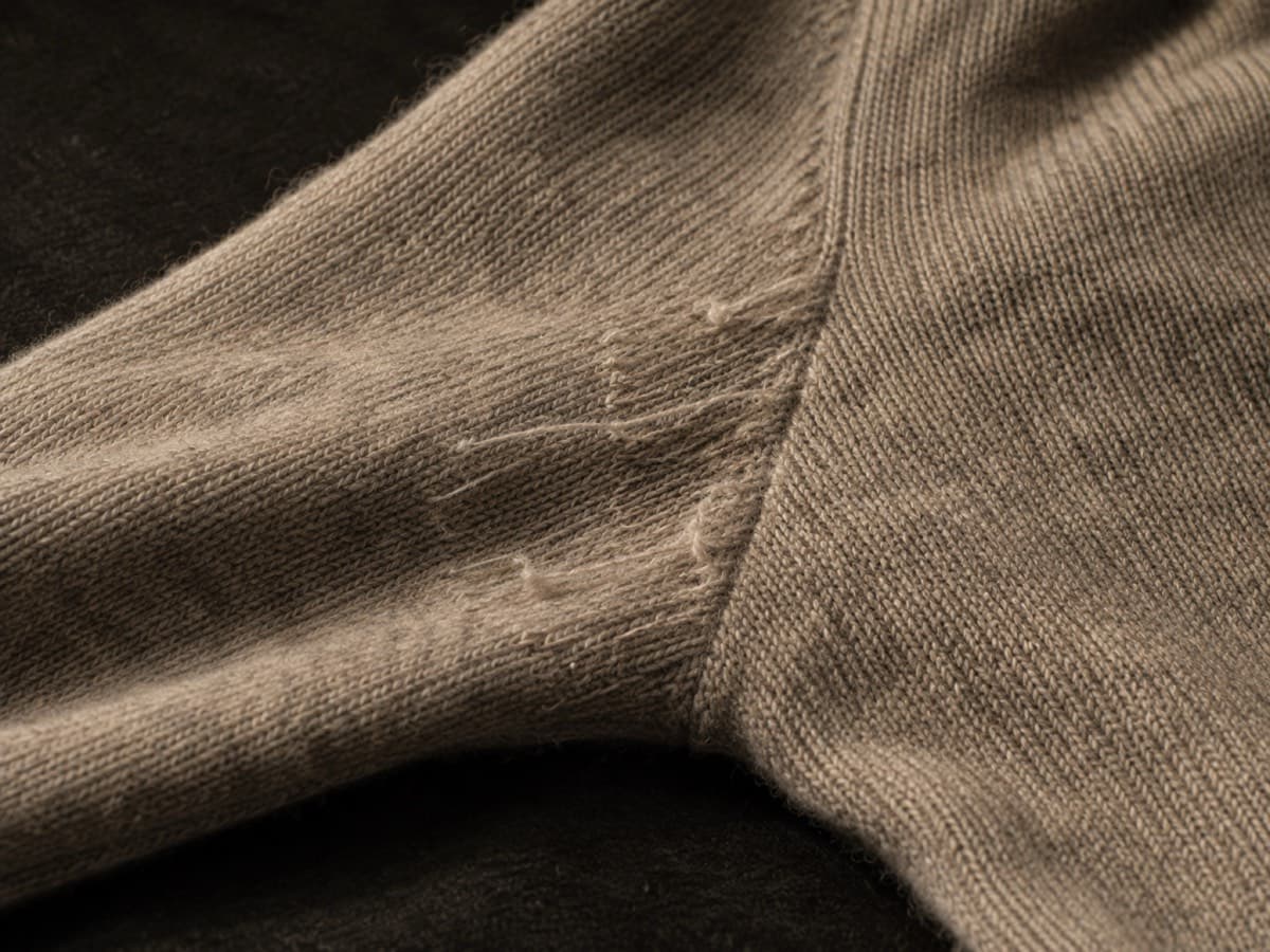 Close-up of pulled snag threads on a wool-silk sweater