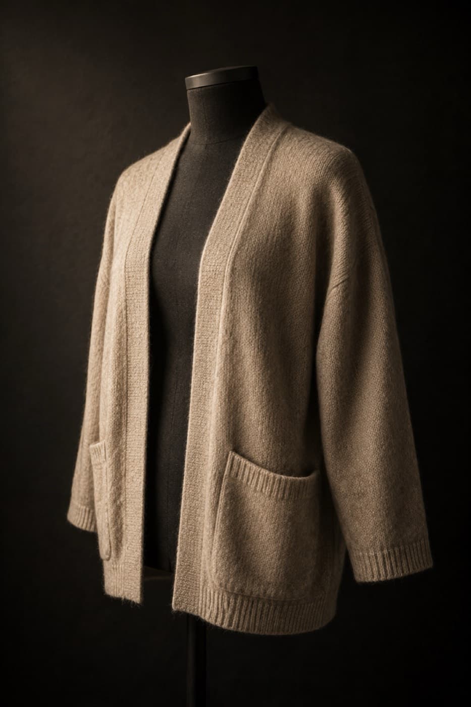 Oatmeal lambswool cardigan with patch pockets on a charcoal dress form